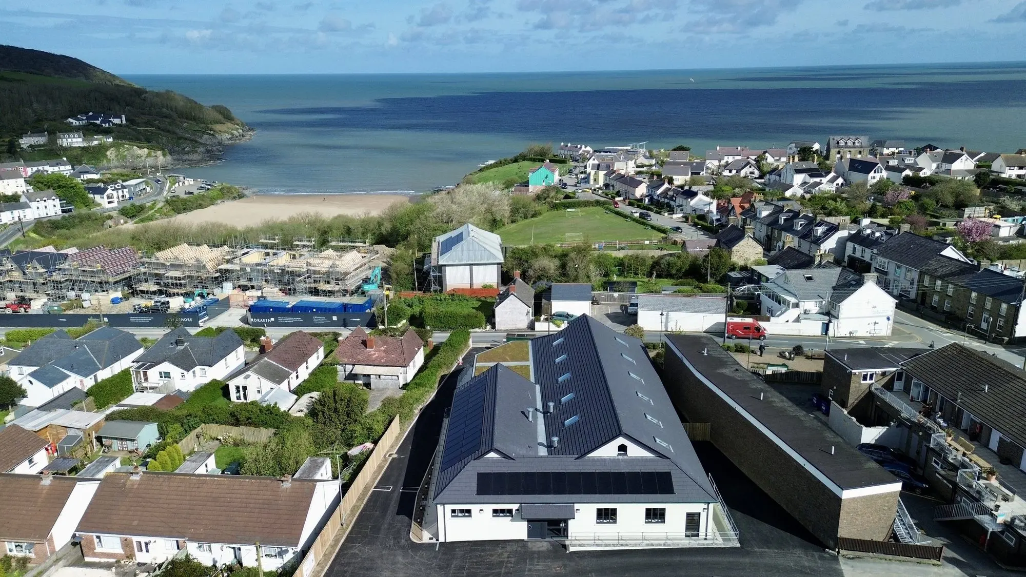 Aerial view of Aber-porth village, the new village hall and Cardigan Bay beyond