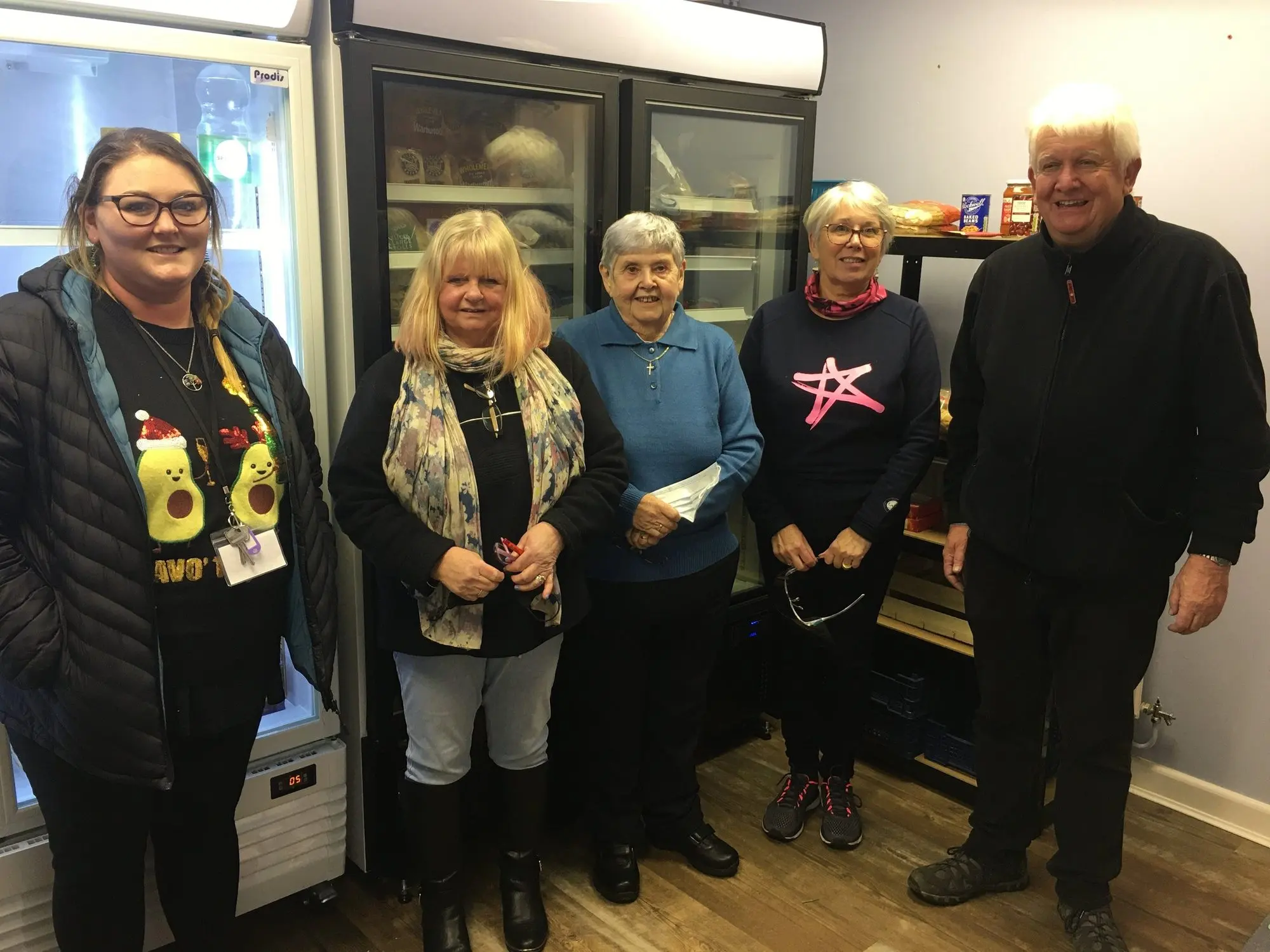 Volunteers beside the community fridge