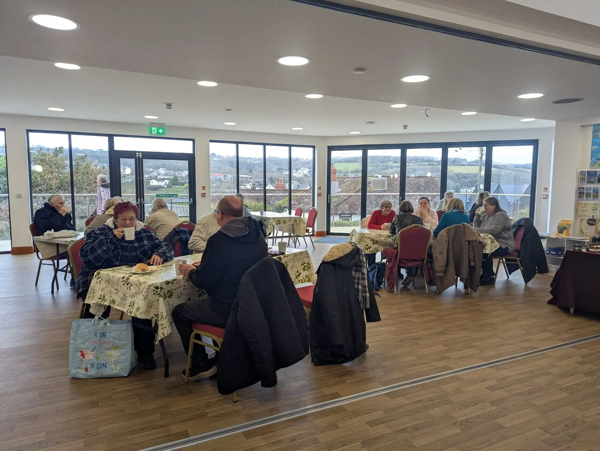 Tables laid for a community lunch in the main hall