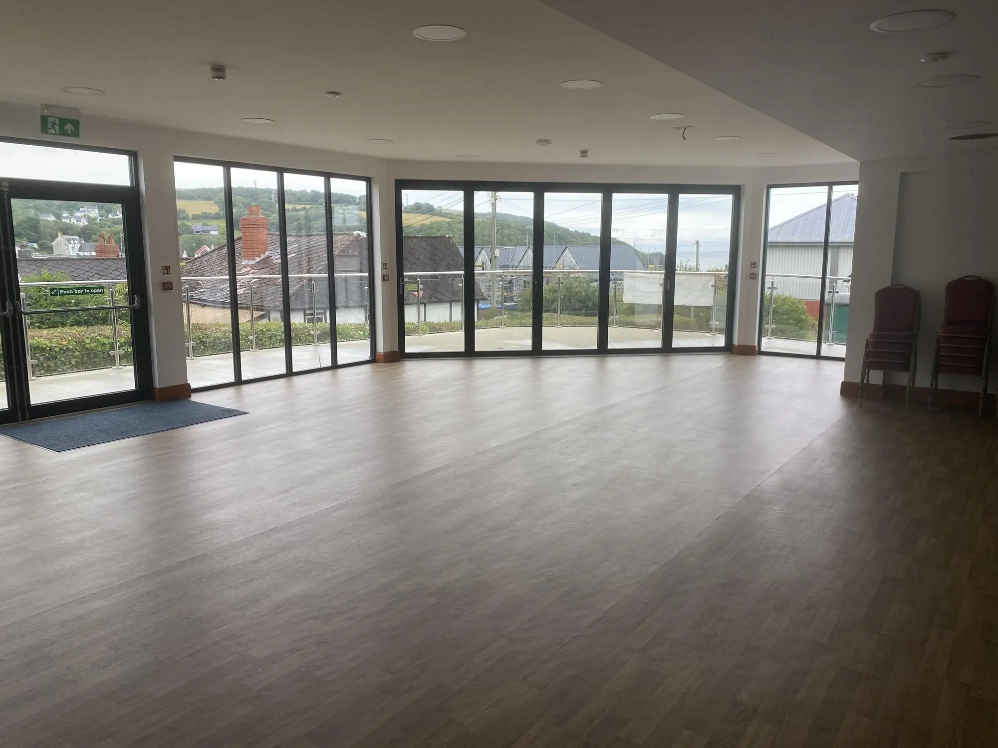 The empty main hall with wooden floor and floor-to-ceiling windows